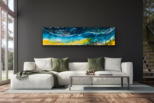 A wide, horizontal oil on canvas painting displayed at Windosr Gallery above a white sofa with green cushions, showing abstract blue and yellow water-like patterns.