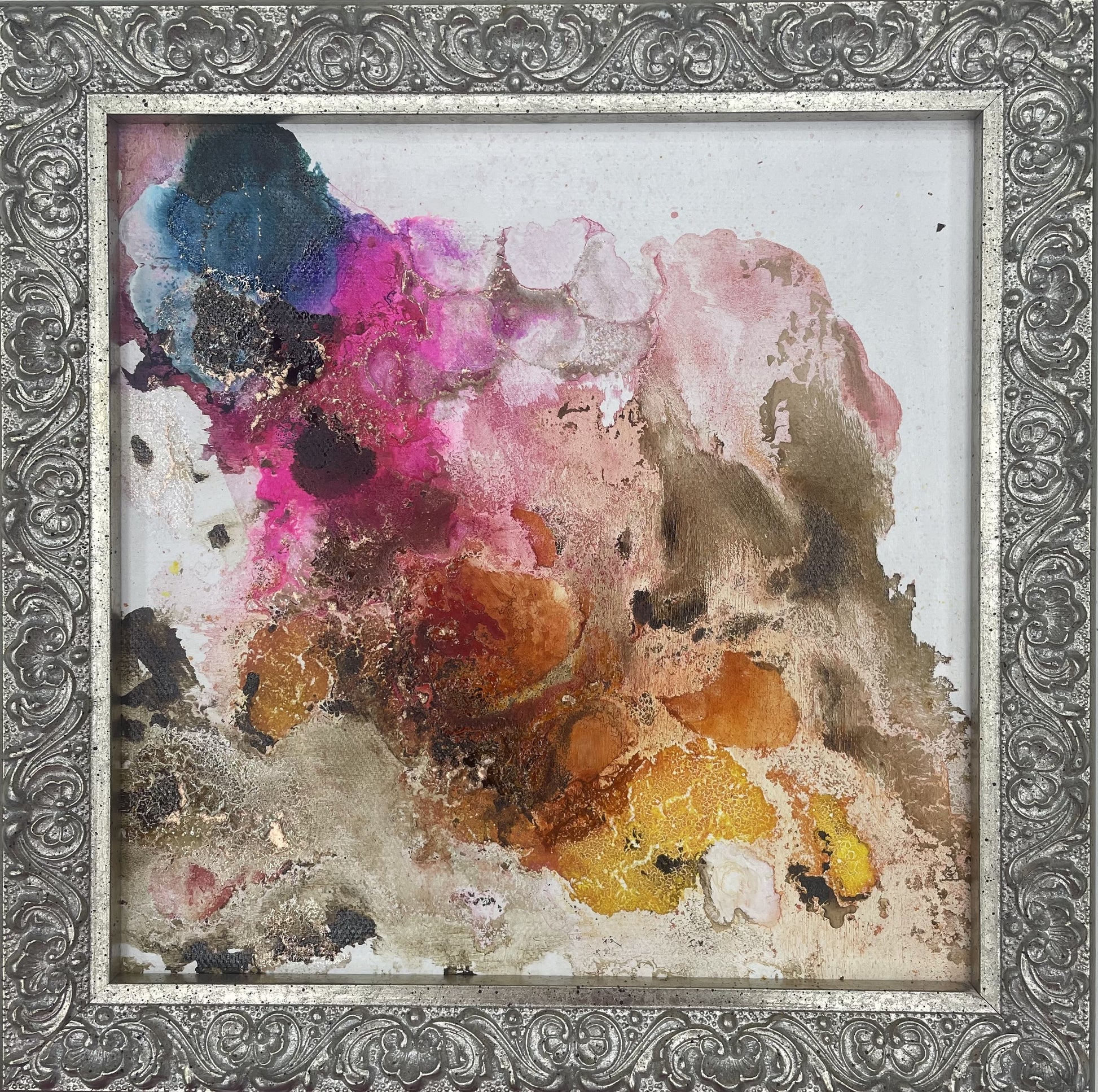 Abstract multicolored painting inside a decorative silver frame