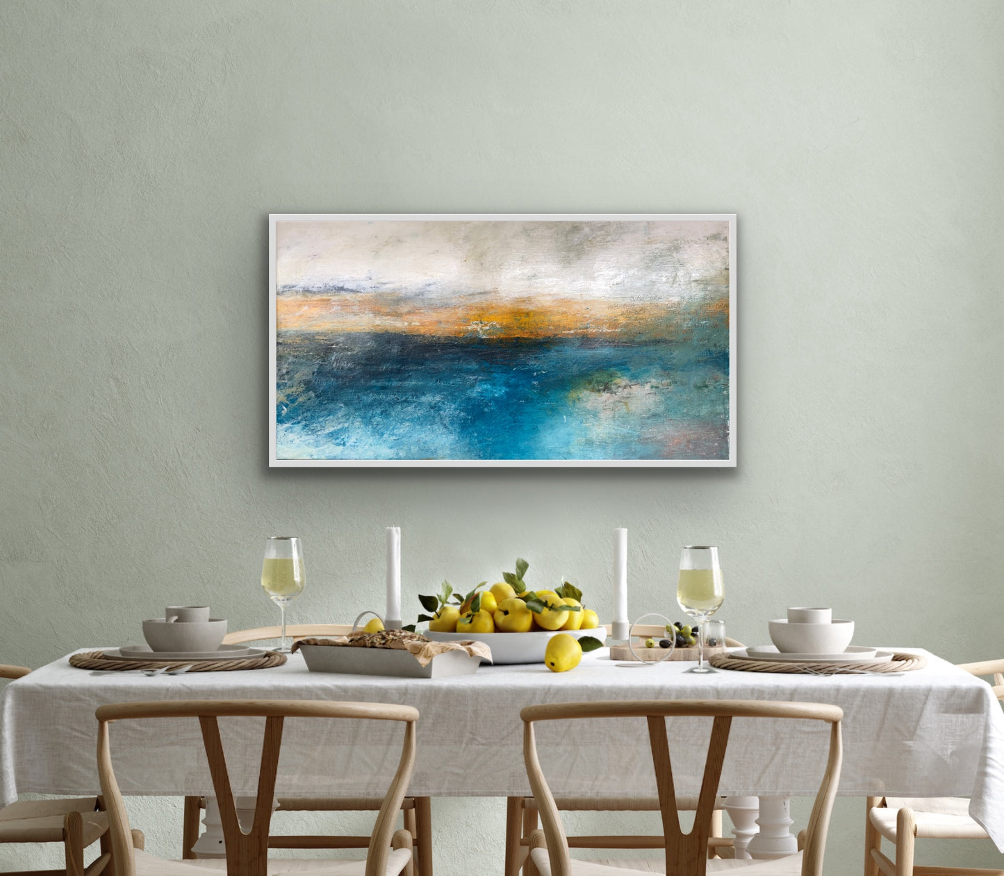 An abstract oil on linen painting displayed above a dining table with white tablecloth and wooden chairs, depicting serene water-like textures in blue and white colors.  The artwork is featured in Windsor Gallery's collection